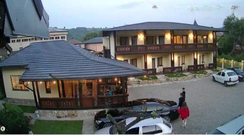 a large house with cars parked in a parking lot at Fexada Home in Vama
