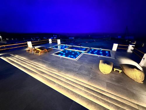 a swimming pool on a ship at night at Aeris suites pori jacuzzi villa in Koufonisia