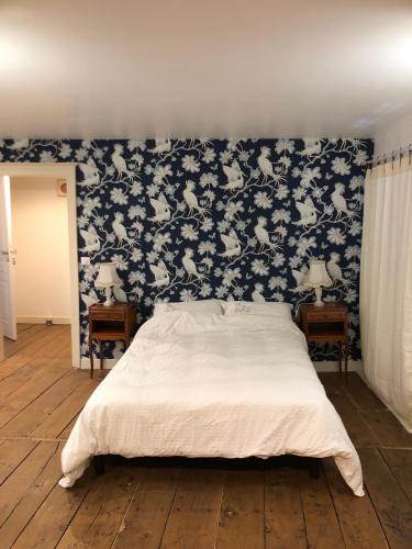 une chambre avec un lit avec un papier peint bleu et blanc dans l'établissement Résidence étoile, à Saint-Yrieix-la-Perche