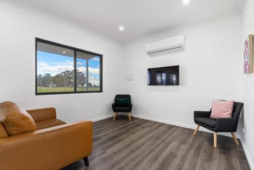 a living room with a couch and two chairs at Glenowrie Cottage - 2 King Beds - Close to Cadia in Millthorpe