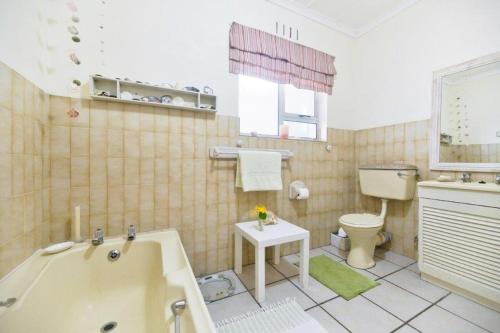 y baño con bañera, aseo y lavamanos. en Oceanview House, en Struisbaai