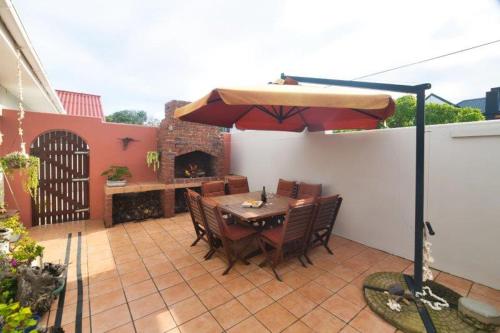 a table and chairs with an umbrella on a patio at Oceanview House in Struisbaai