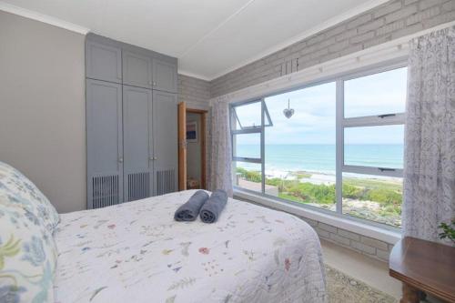 1 dormitorio con 1 cama y vistas al océano en Oceanview House, en Struisbaai