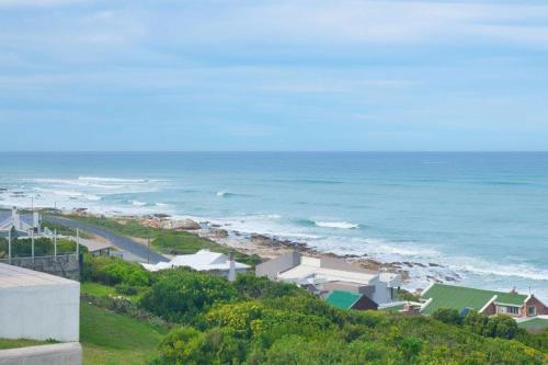 a view of a beach with the ocean and houses at Oceanview House in Struisbaai