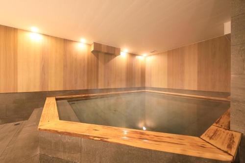jacuzzi en una habitación con paredes de madera en QuintessaHotel SapporoSusukino63 Relax&Spa, en Sapporo