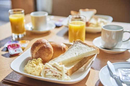 una mesa con un plato de alimentos para el desayuno y zumo de naranja en Urayasu Sun Hotel - Vacation STAY 33022v, en Urayasu