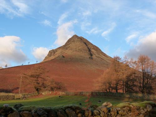 a mountain in the middle of a field with trees at Rowan in Ulverston