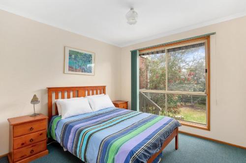 a bedroom with a bed and a window at 38 Bayview Drive in Cowes