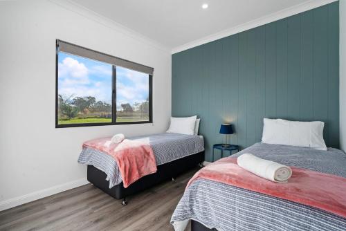 a bedroom with two beds and a window at Glenowrie Cottage - 1 King 2 Singles - Farm Stay in Millthorpe