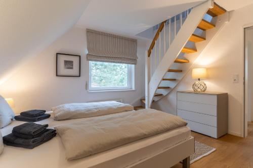 a bedroom with a bed and a staircase at Reetdachhaus Dünen Lounge in Böhl