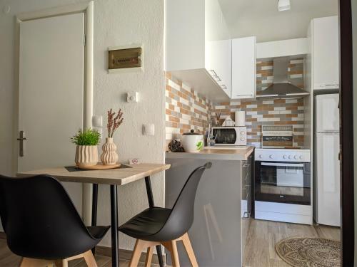 a kitchen with a table and chairs in a room at Pietra di Luna 1 in Kriopigi