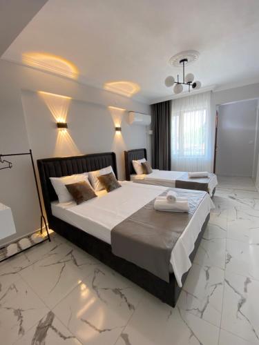 a hotel room with two beds and a television at Bavella House in Pamukkale
