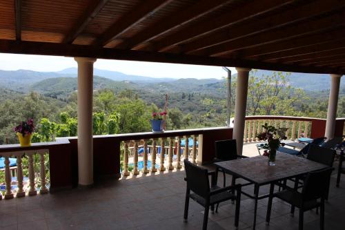 a balcony with a table and chairs and a view at Villa PANGALIS Romantica in Kato Pavliana
