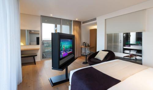 a bedroom with a bed and a tv in a room at Cramim by Isrotel Exclusive in Qiryat ‘Anavim