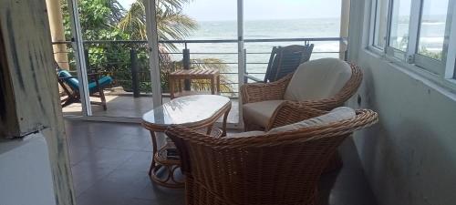 a balcony with chairs and a table and a view of the ocean at Toddy by windy in Unawatuna