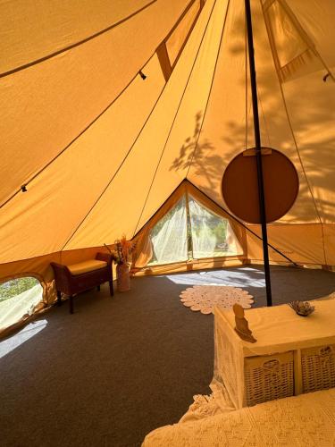a tent with a table and a bench in it at Glamping on idyllic lake, paddle boards & rowboat in Porsgrunn