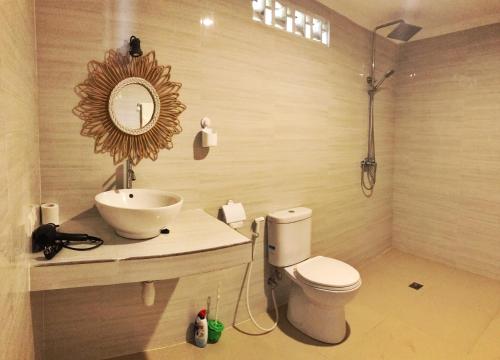 a bathroom with a sink and a toilet and a mirror at Namali Villa Gili Trawangan in Gili Trawangan