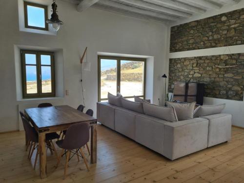 Aviola Mykonos في فتيليا: غرفة معيشة مع أريكة وطاولة