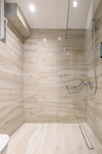 a bathroom with a glass shower with a toilet at Nicolas Grand Suites, Adults Only in Kardamaina