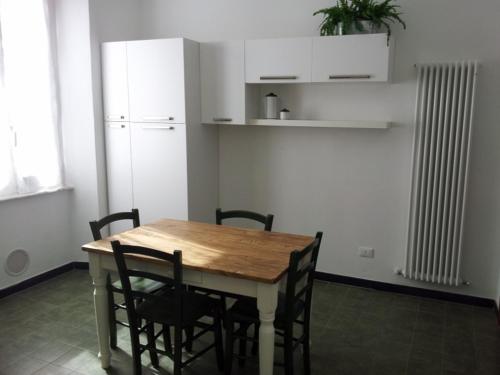 Una cocina con una mesa con sillas y un refrigerador. en La Casa al Mare, en Lerici