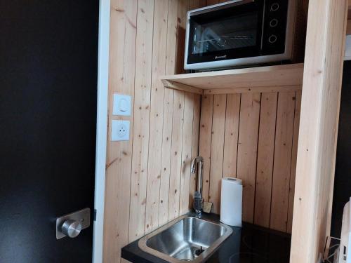 une petite cuisine avec un évier et un micro-ondes dans l'établissement Résidence Nova - Studio pour 2 Personnes 244, à Arc 1800