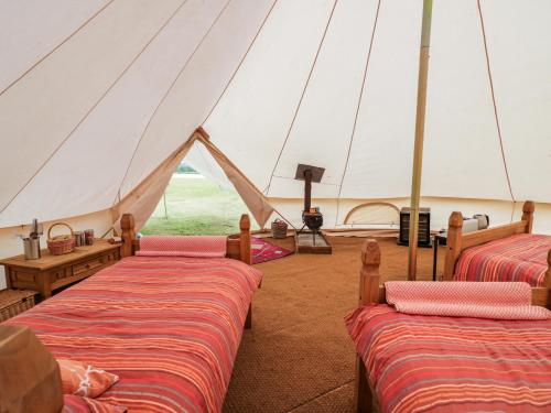 a marquee with two beds in a tent at Tumbling Tom in Worcester