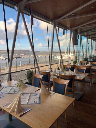 a restaurant with tables and chairs with a view of the beach at Speicher Barth - Superior-Hotel in Barth