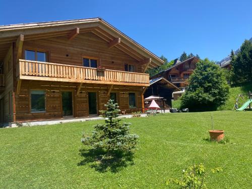 a log cabin with a christmas tree in the yard at Chalet Vicky et Nino in Les Diablerets
