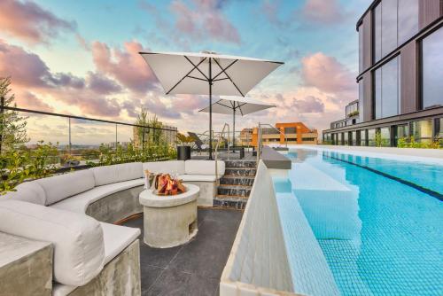 an outdoor swimming pool with a fireplace next to a building at Veriu Collingwood in Melbourne