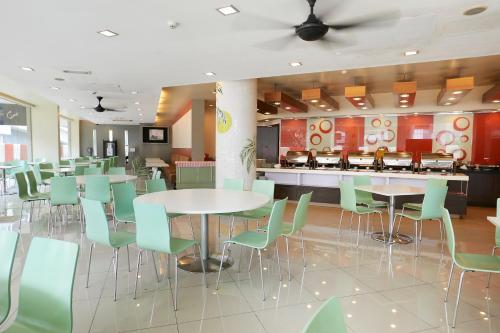 a cafeteria with tables and chairs and a counter at Grand Pacific Hotel in Kuala Lumpur