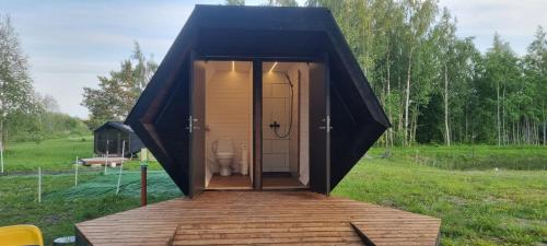 a black tent with a toilet in a field at Ku:Kärg in Põldeotsa