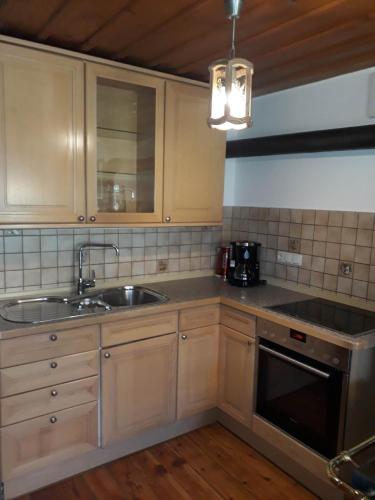 a kitchen with wooden cabinets and a sink at Haus Widlbrandlehen in Schönau am Königssee