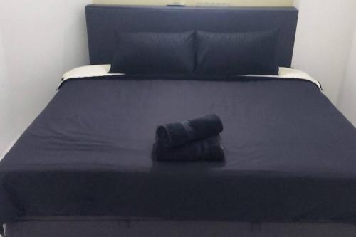 ein schwarzes Bett mit einem rollenden Handtuch drauf in der Unterkunft 1Bedroom SeaView StudioApartment in Kuah