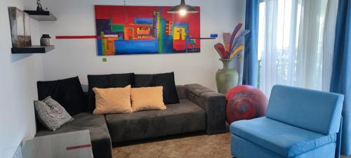 a living room with a couch and a blue chair at Art Gallery House with a small relaxing pool in Crikvenica