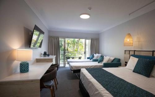 een hotelkamer met 2 bedden en een bank bij Tangalooma Island Resort in Tangalooma