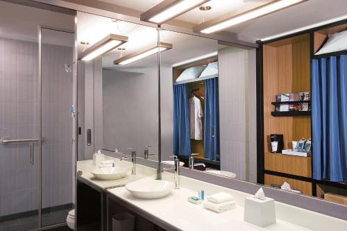 a bathroom with two sinks and a large mirror at Aloft Dynamic Town in Longgang