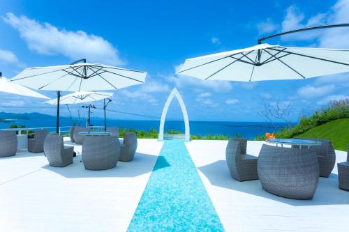 a patio with tables and umbrellas and the ocean at Jukaitei in Kyotango