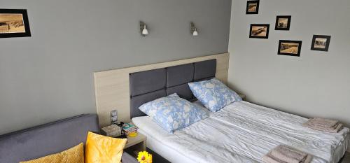 a bedroom with a bed with blue pillows on it at Apartamenty Przy Morzu Dominikana in Sianozety