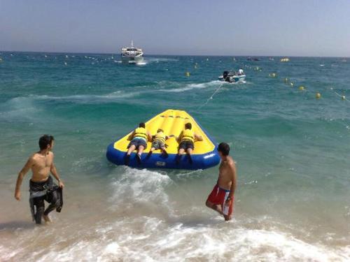 a group of people on the beach with a yellow raft at Estudio Paz in Lloret de Mar
