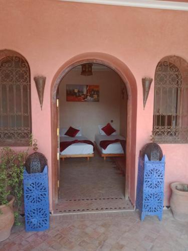 a bedroom with two beds in a pink house at Atlas Resorts in Aït Ourir
