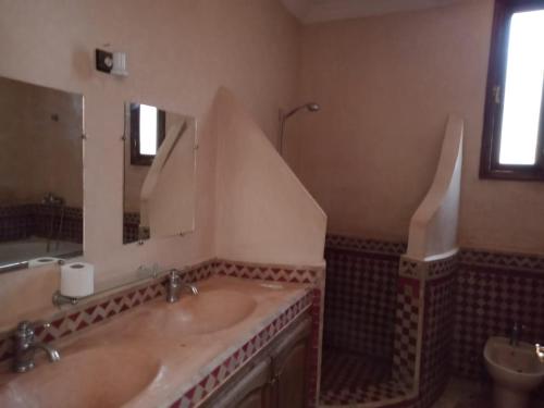 a bathroom with two sinks and a large mirror at Atlas Resorts in Aït Ourir