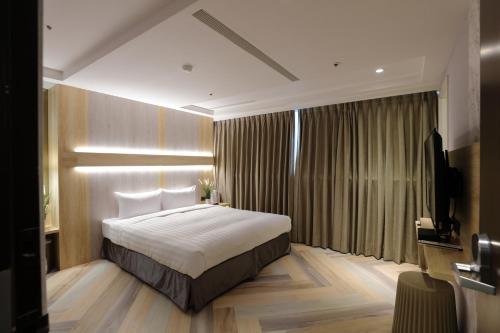 a hotel room with a bed and a television at Silken Hotel in Taipei
