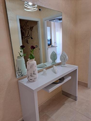 a bathroom with a mirror and a counter with vases on it at B&B ReLu' in Gallipoli