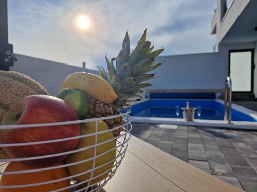 a basket of fruit on a table in a kitchen at Vila Geminos I in Srima