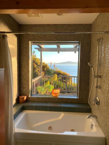 eine große Badewanne im Bad mit Fenster in der Unterkunft Spectacular SF Bay Front House with Dramatic Views in Richmond