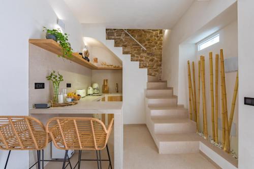 a staircase in a house with two chairs and a counter at Carioca Kiwi House - Centro Histórico in Tarifa