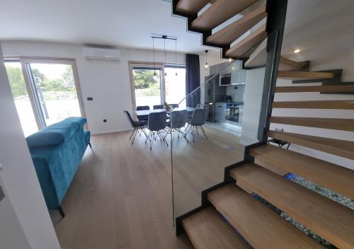a living room with a blue couch and a staircase at Vila Geminos I in Srima