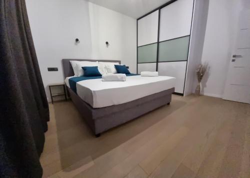 a bedroom with a large bed with blue pillows at Vila Geminos I in Srima