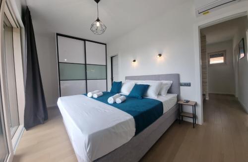 a bedroom with a large bed with blue pillows at Vila Geminos I in Srima