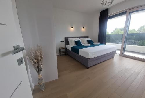 a bedroom with a bed and a large window at Vila Geminos I in Srima
